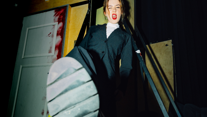 Jaunietis, kas izstiepis kurpes zoli pret attēla vidusdaļu