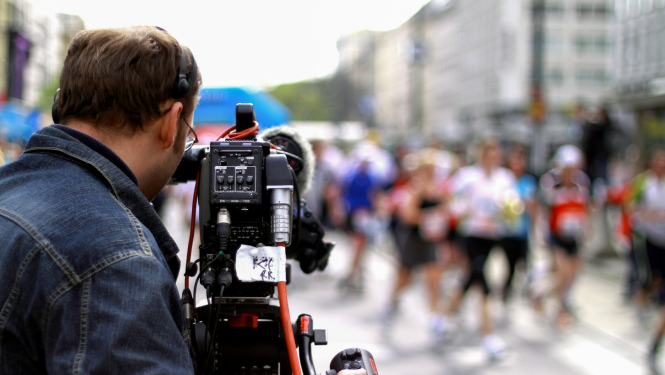 TV kameras operators filmējot publisku pasākumu pilsētvidē