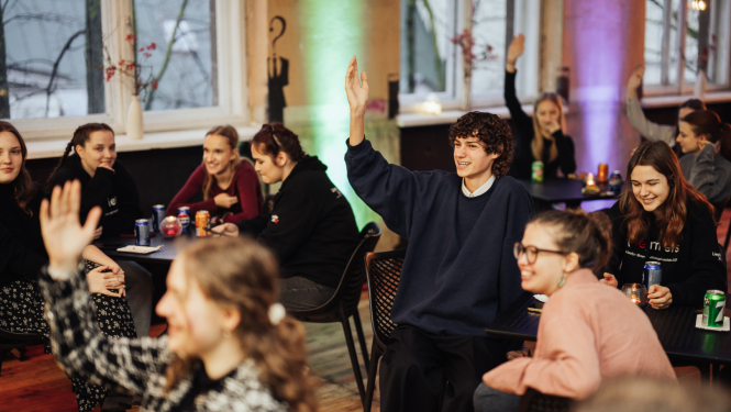 Tartu jaunieši sēžot, dzerot limonādes, daļa pacēluši roku