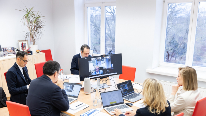 Pieci cilvēki pie datoriem telpā