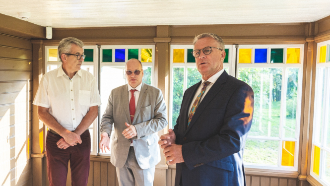 Trīs cilvēki muzeja telpās