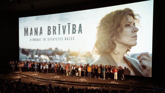 Cilvēku grupa uz skatuves filmas pirmizrādē