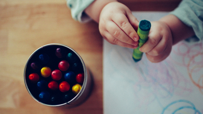 Bērna rokas un krāsaini krītiņi