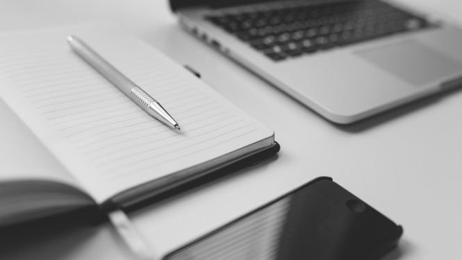 Dators un piezīmju blociņš uz galda