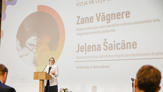 Sieviete uz skatuves saka runu izlaidumā