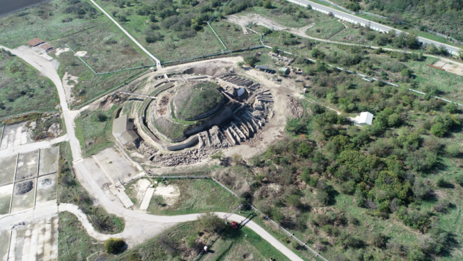 No gaisa fotografēta ainava ar zaļu vidi, centrā ir liels apaļš objekts - Provadijas sāls raktuves