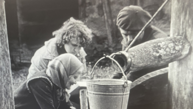 Kadrs no filmas, trīs cilvēki pumpē ūdeni