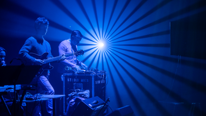 Mūziķi uz apgaismotas skatuves