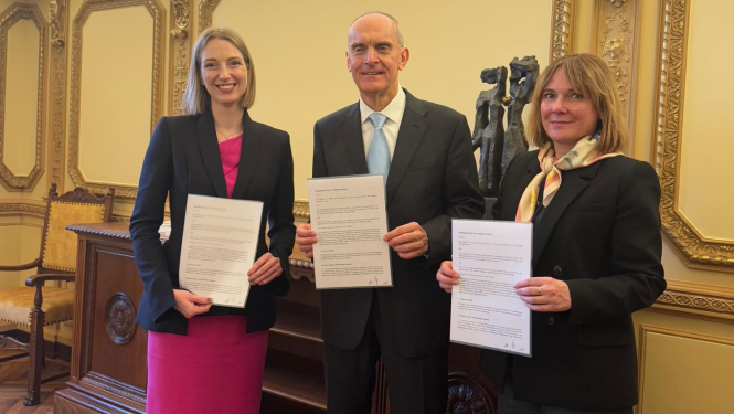 Trīs cilvēki memoranda parakstīšanas brīdī