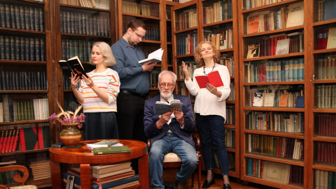 Ģimene četru cilvēku sastāvā pie grāmatplaukta