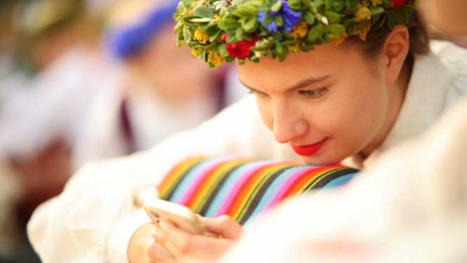 Dziesmu un Deju svētku dalībniece ar viedtālruni