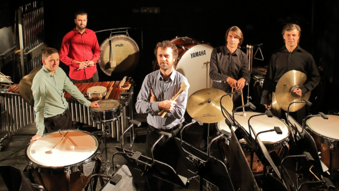 Četri sitaminstrumentu mūziķi uz skatuves