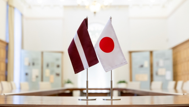 Latvijas karogs un Japānas karogs sanāksmju telpā uz galda