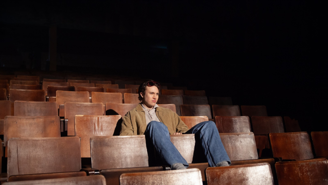 Aktieris skatītāju zālē uz krēsliem