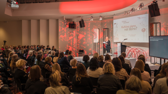 "Liepāja - Eiropas kultūras galvaspilsēta 2027" konferences norise ar pasākuma moderatoru uz skatuves un skatītājiem zālē