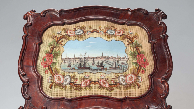 Nošu turētājs. 19. gs. vidus. Koks; virpots, kokgriezums. Tekstils, stikla pērlītes; pērlīšu izšuvums, dekoratīvs gleznojums. 2021. gadā restaurējis Dainis Andersons, interjera iekārtas priekšmetu (mēbeļu) restaurators.