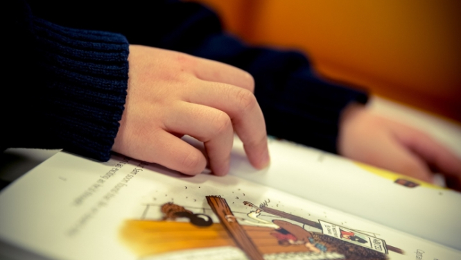 bērns lasa grāmatu