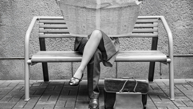 Izrādes afiša. Foto ar soliņu un cilvēku, kurš lasa avīzi