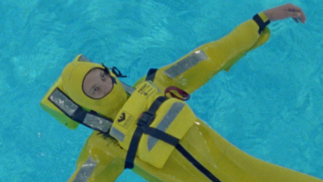 Kadrs no filmas – peldētājs dzeltenā kombinezonā