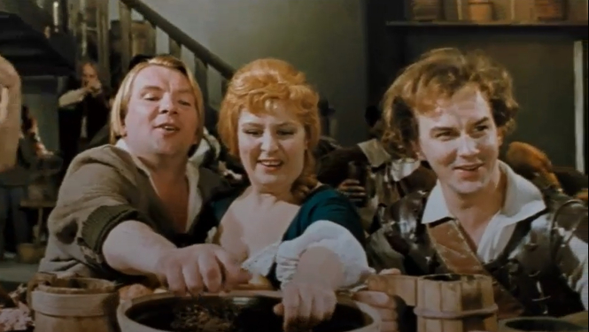 Filmas kadrs, cilvēki svin pie galda