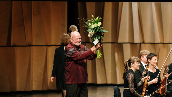 Komponists Pēteris Vasks uz skatuves Cēsu koncertzālē saņemot ziedus