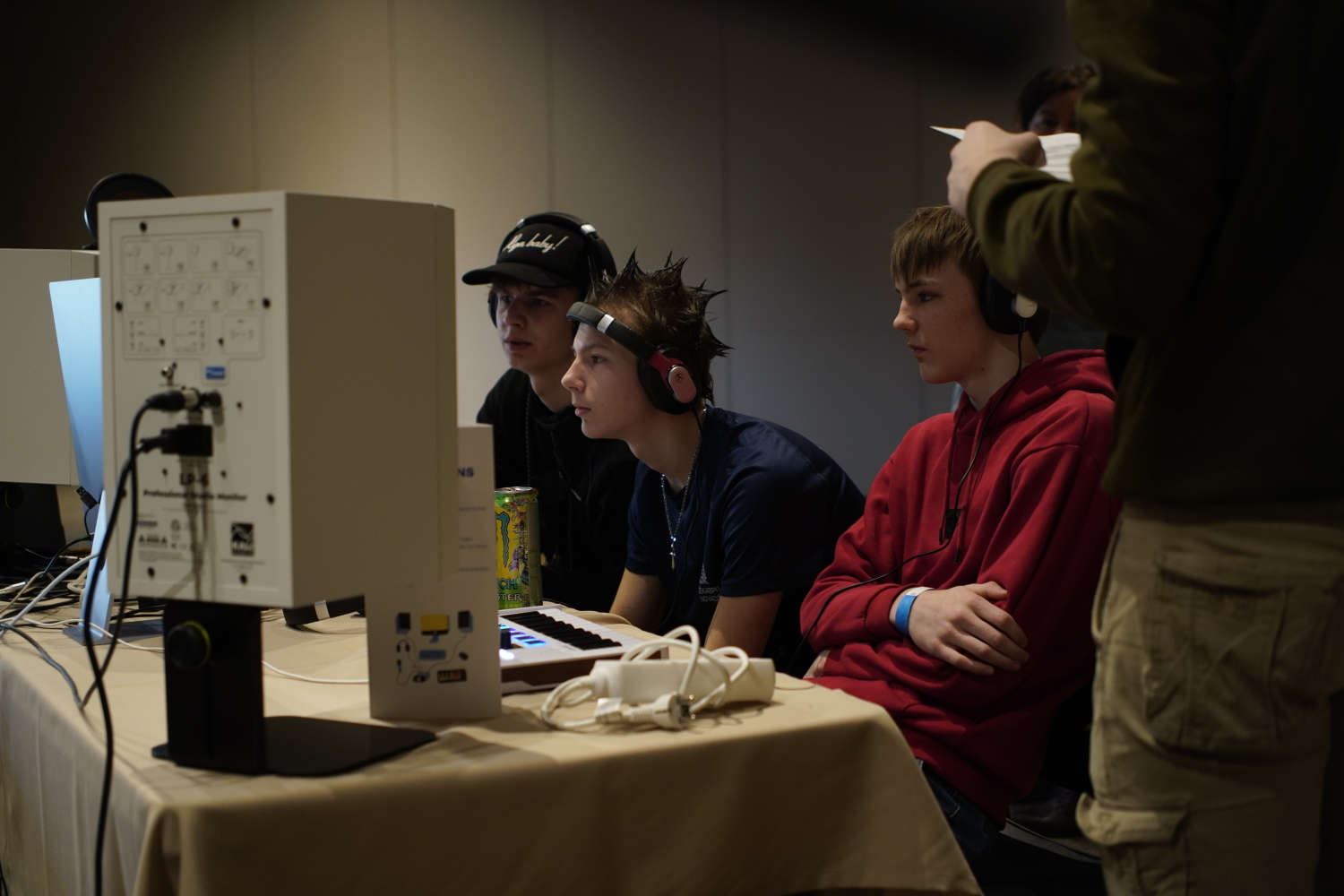 Jaunieši pie galda ar dažādām tehnoloģijām