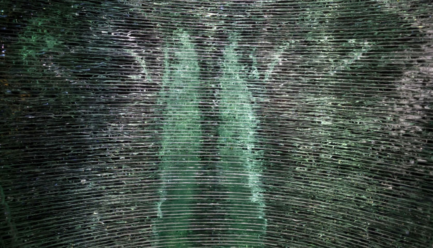 Zaļganmelna stikla darba fragments no Baltijas mūsdienu stikla mākslas izstādes “Slāņi” 