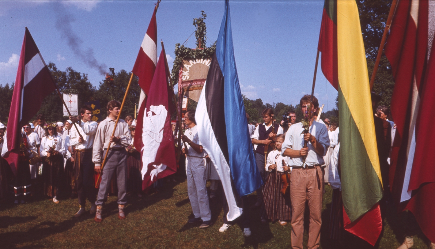 Cilvēki ar karogiem Turaidā