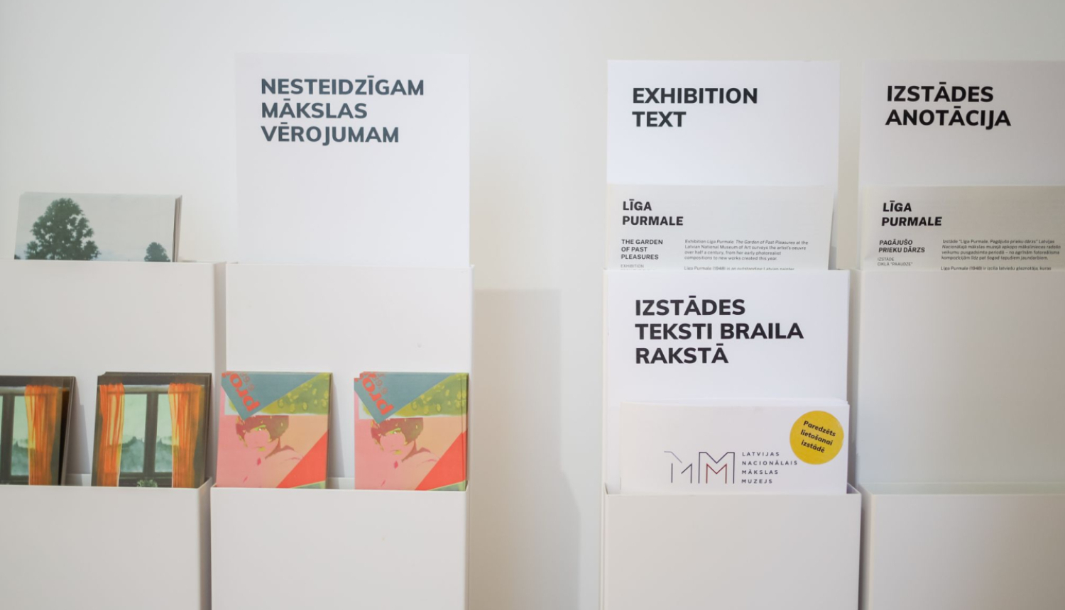 Stendi ar informatīvajiem materiāliem Līgas Purmales personālizstādē “Pagājušo prieku dārzs” Latvijas Nacionālajā mākslas muzejā. 2025. Foto: Estere Rožkalne