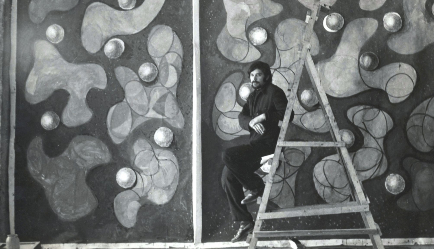 Jānis Krievs pie vitrāžas sienas projekta Rīgas sporta pilī. 1970. Publicitātes foto