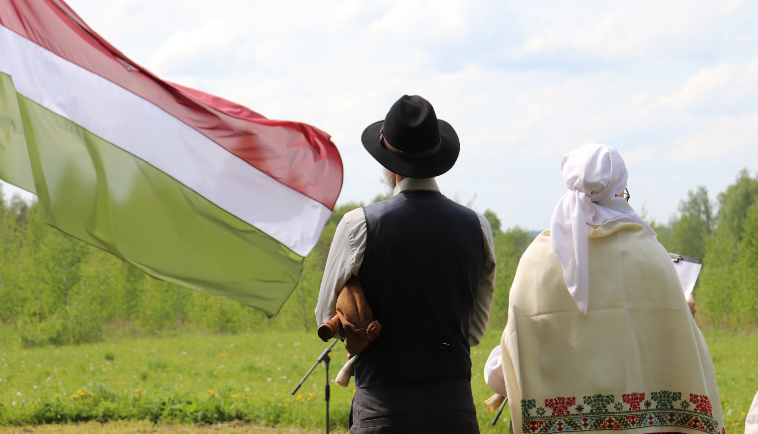 Divi cilvēki Sēlijas tautas tērpos un Sēlijas karogs