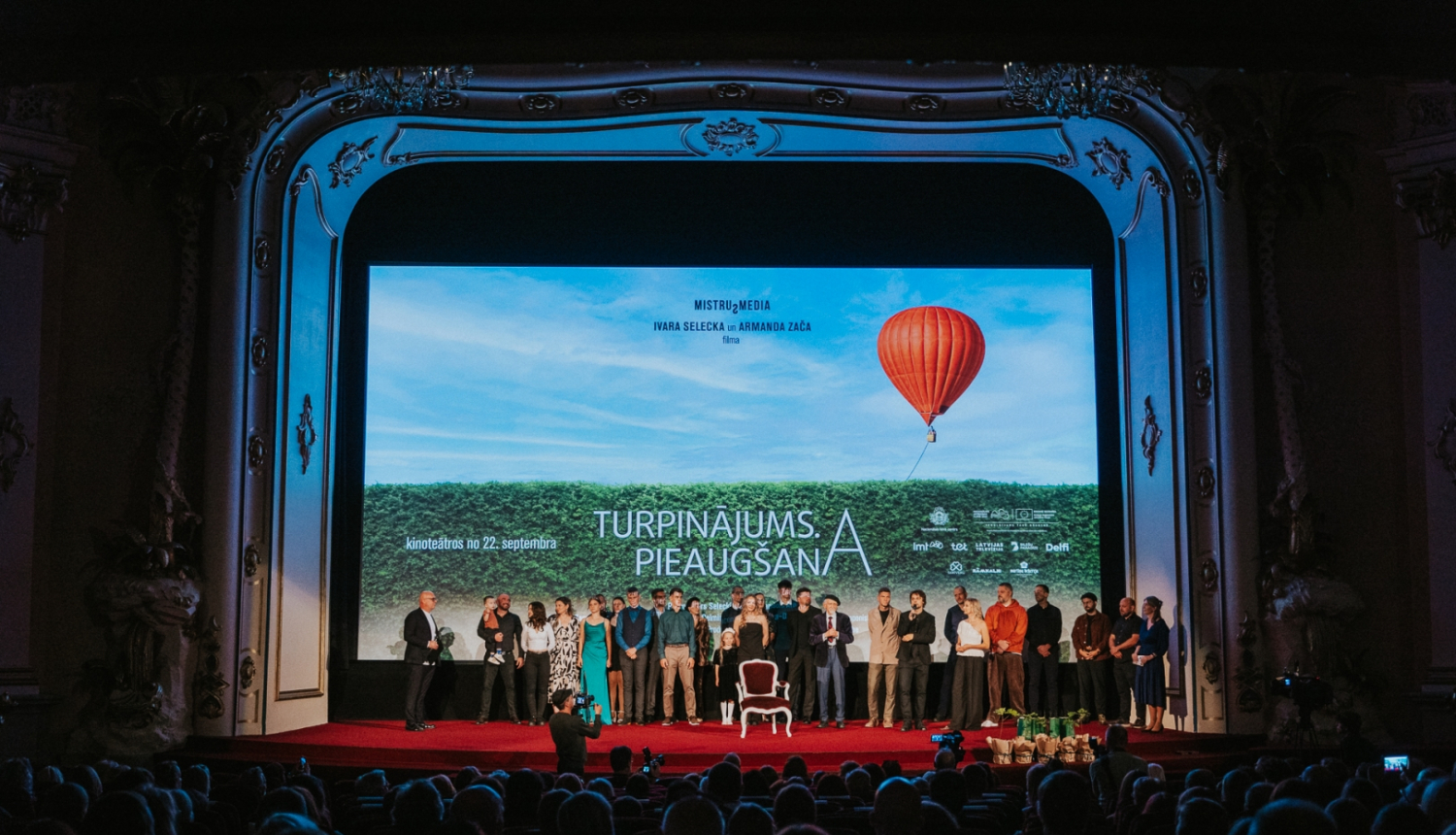 Cilvēki pirmizrādē uz skatuves