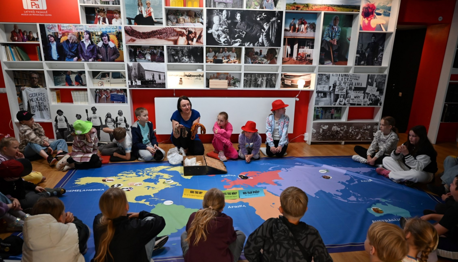 Muzeja pārstāve un bērni muzejā