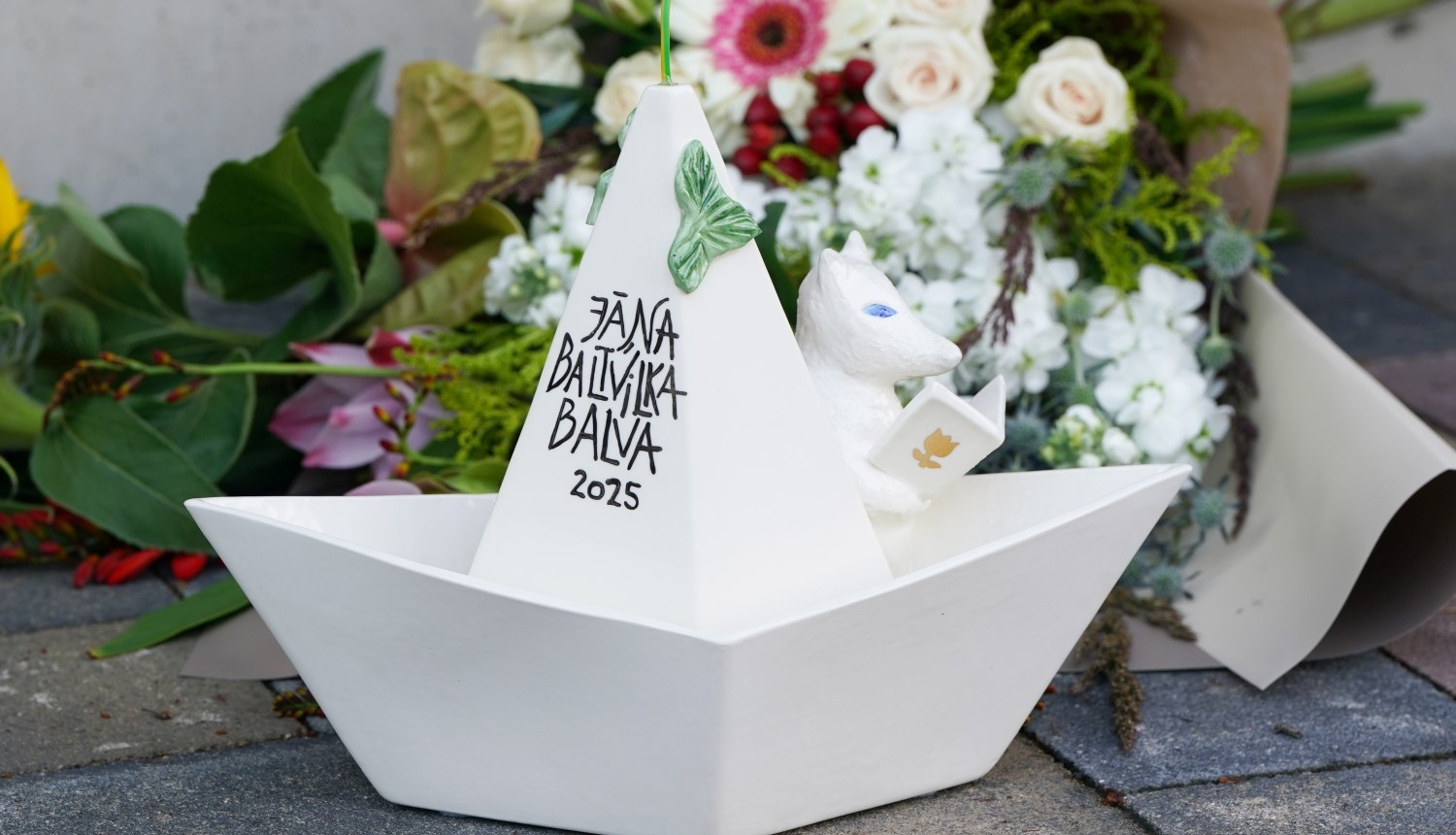 Starptautiskā Jāņa Baltvilka balva 2025 ar puķu pušķi fonā