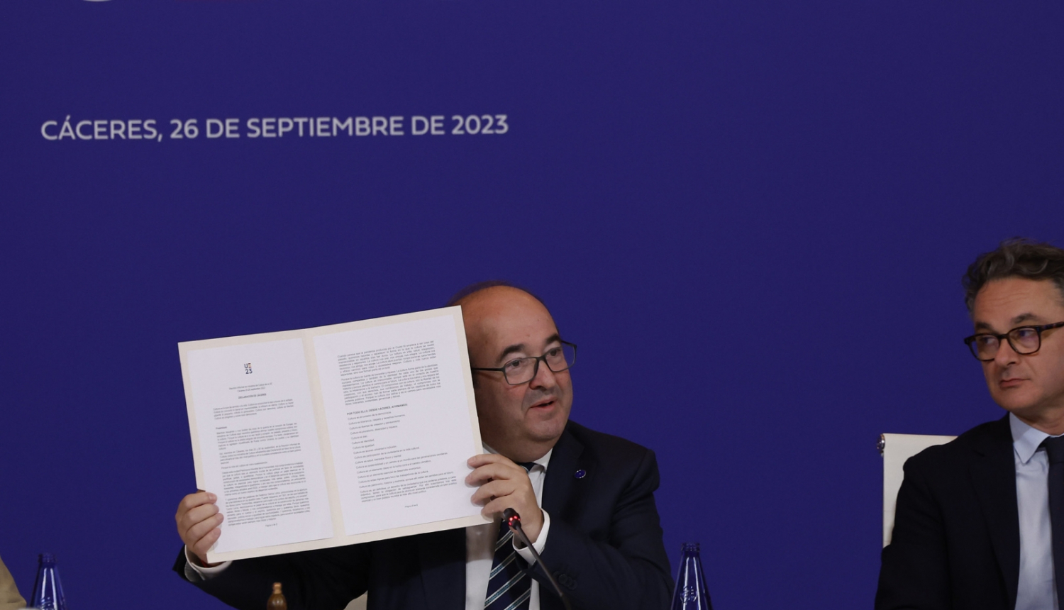 Divi vīrieši pie galda preses konferencē