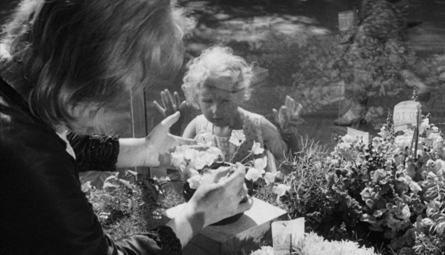 Kadrs no filmas "Baltie zvani" (1961), kadrā meitenīte un ziedu pārdevēja