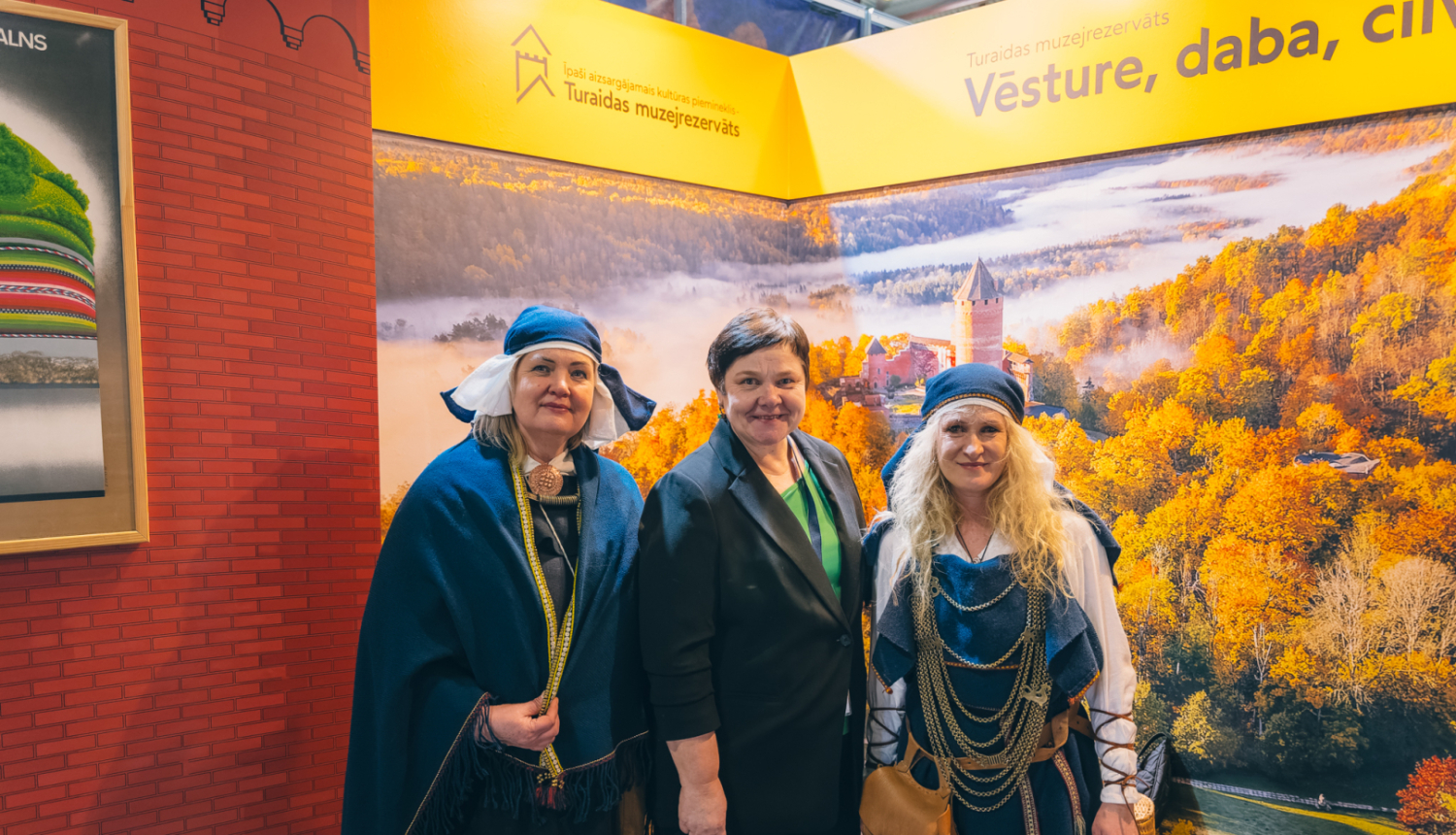 Turaidas muzejrezervāta direktore Jolanta Borīte ar kolēģēm lībiešu tērpos tūrisma izstādes “Balttour 2026” stendā 