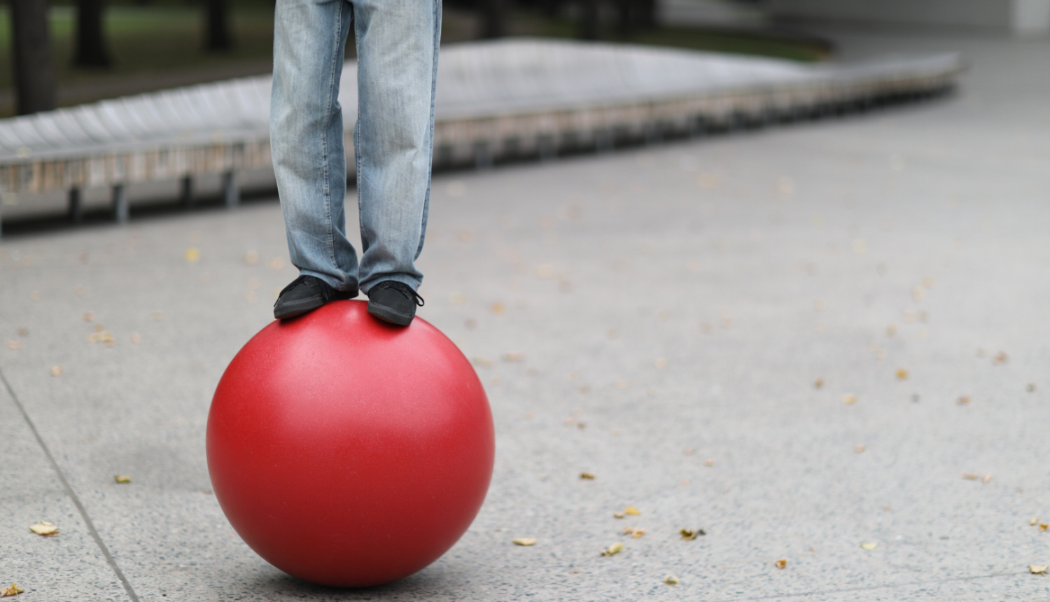 Uz sarkanas bumbas stāv cirka akrobāts