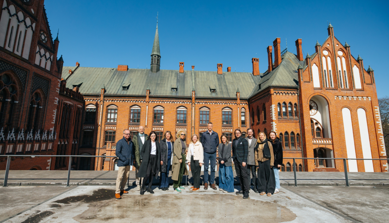 Latvijas Mākslas akadēmijas un mājokļu attīstītāja “Bonava Latvija” pārstāvju grupas foto Latvijas Mākslas akadēmijas pagalmā