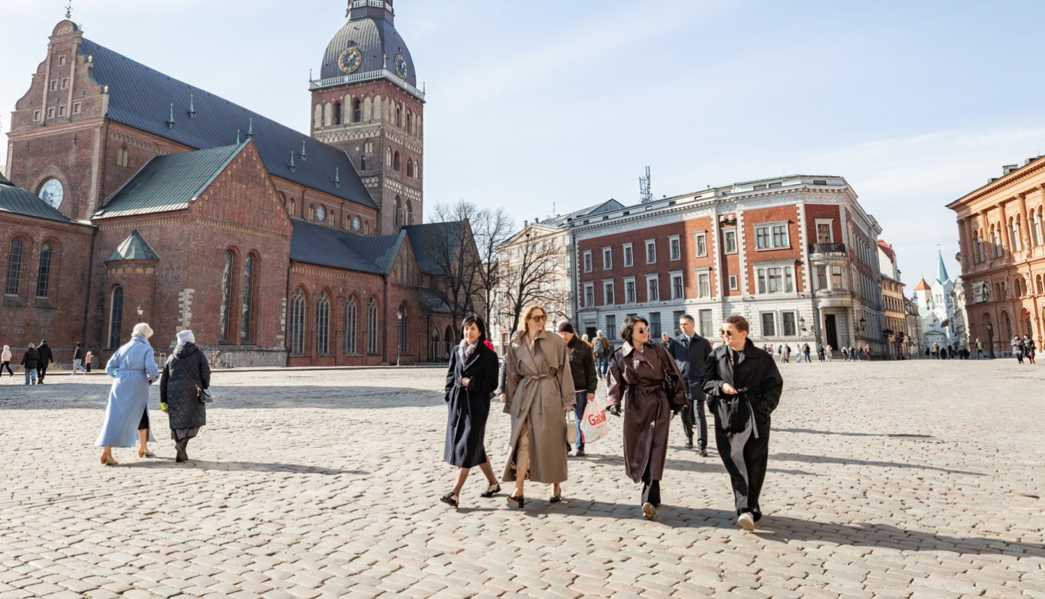 Latvijas, Igaunijas, Lietuvas un Polijas kultūras ministres ar kājām dodas pāri Doma laukumam, fonā Doma baznīca