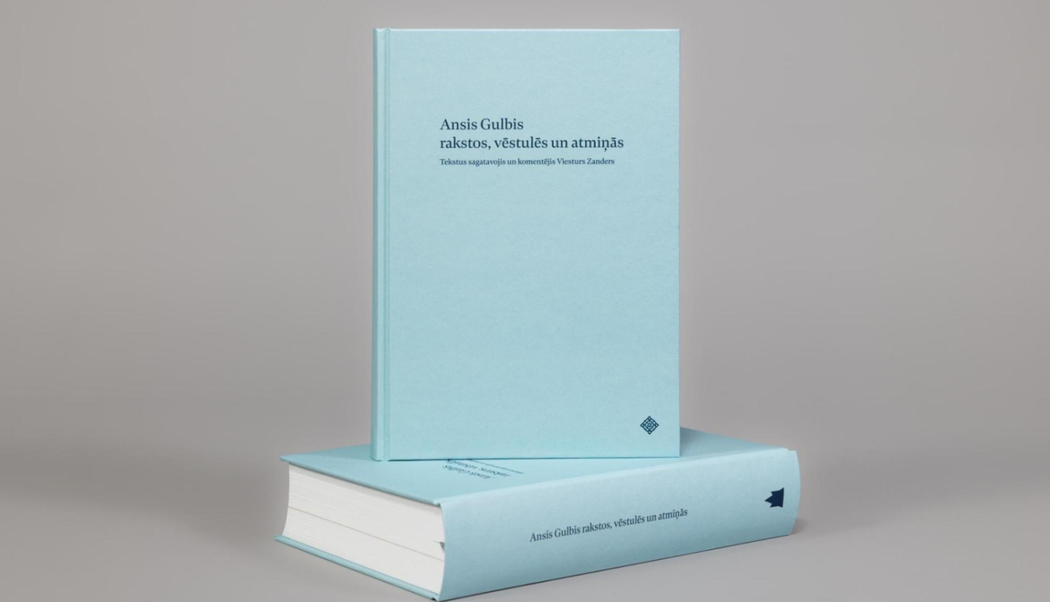 Divas Avotu izdevuma “Ansis Gulbis rakstos, vēstulēs un atmiņās” grāmatas gaiši zilos vākos uz pelēka fona