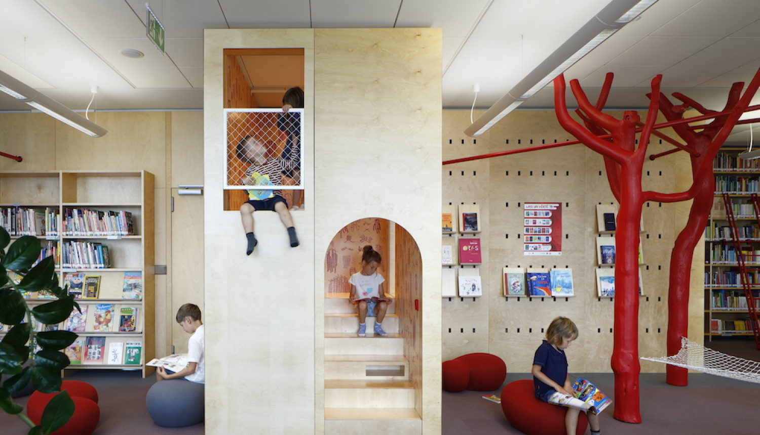 Bērni skatās un lasa grāmatas Latvijas Nacionālās bibliotēkas lasītavā