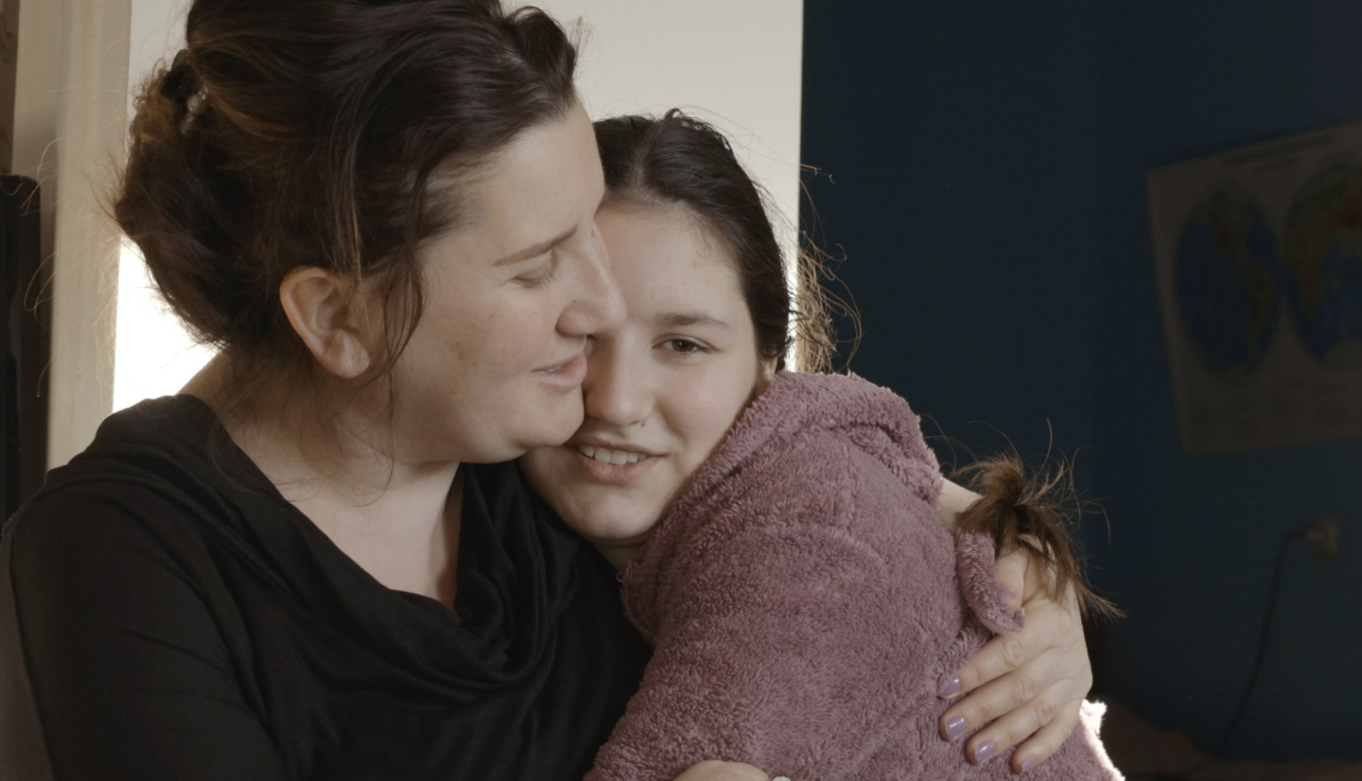 Māte apskauj savu pusaugu meitu