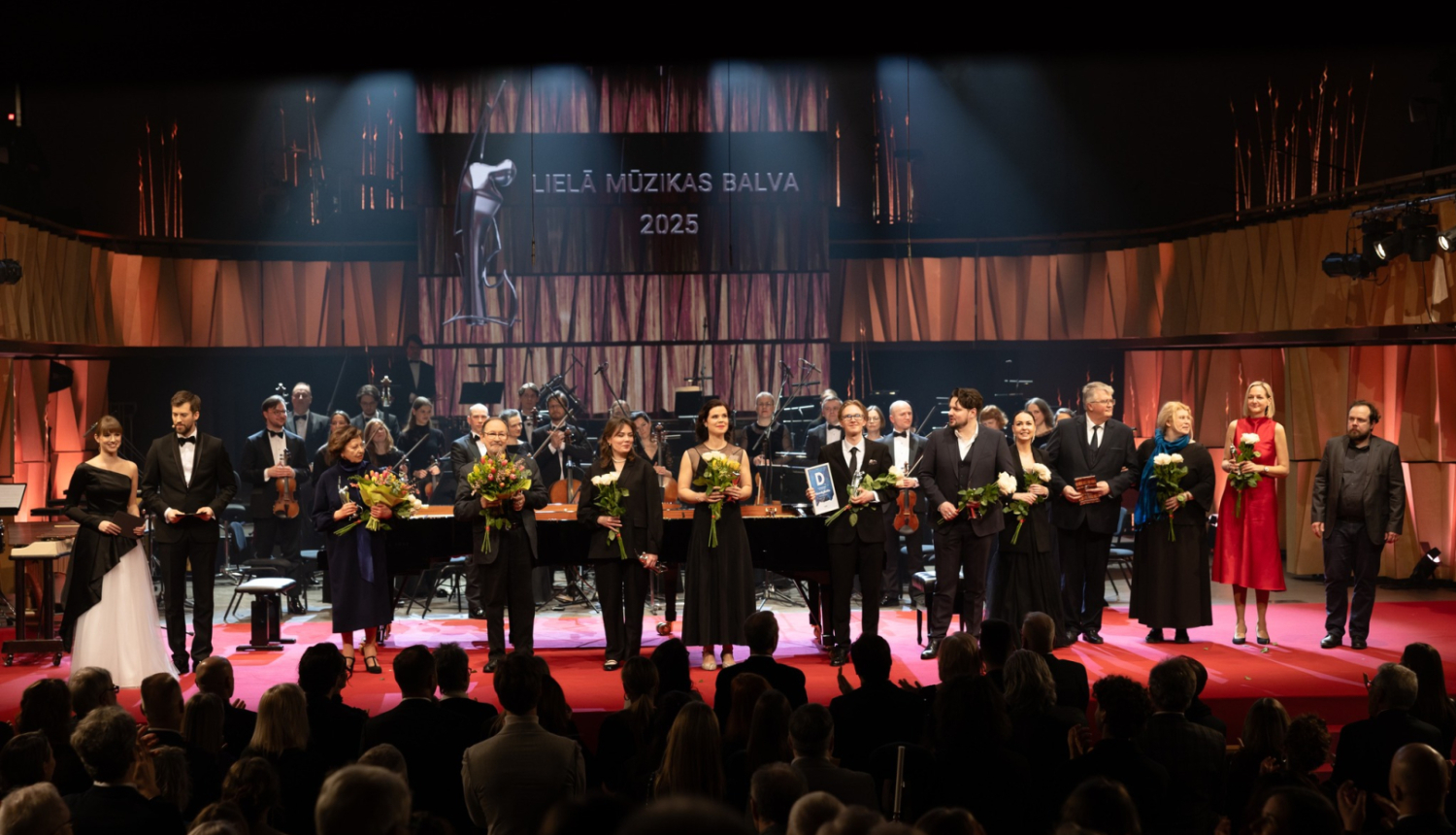 Lielās mūzikas balvas ceremonijas norises koncertzālē CĒSIS. Uz skatuves orķestris un laureāti.