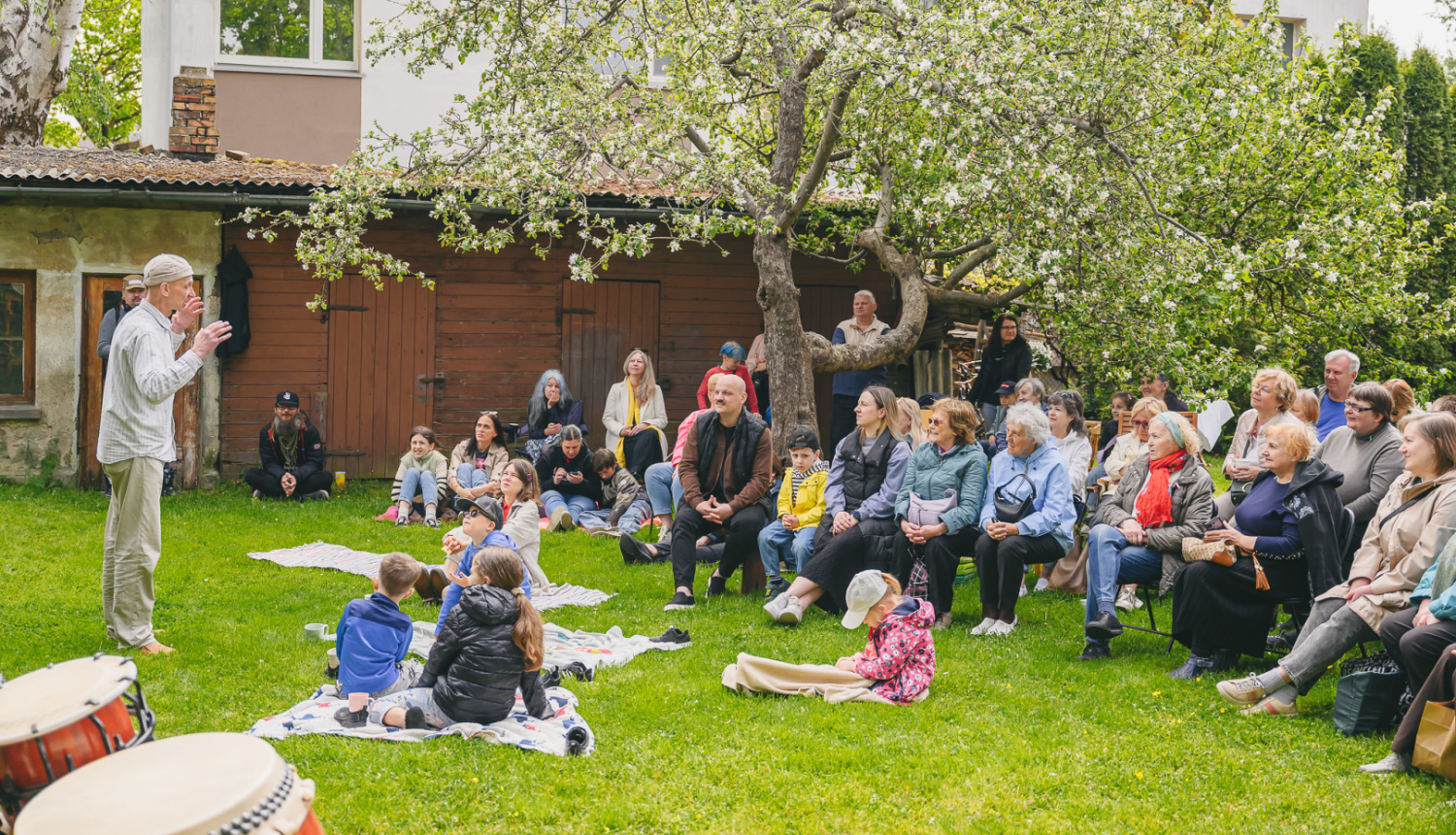 Cilvēku grupa kopienas programmas pasākumā plašā pagalmā