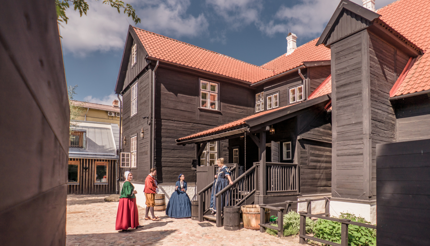 Liepājas Hoijeres nama pagalms ar vēsturiskos kostīmos ģērbtām darbiniecēm