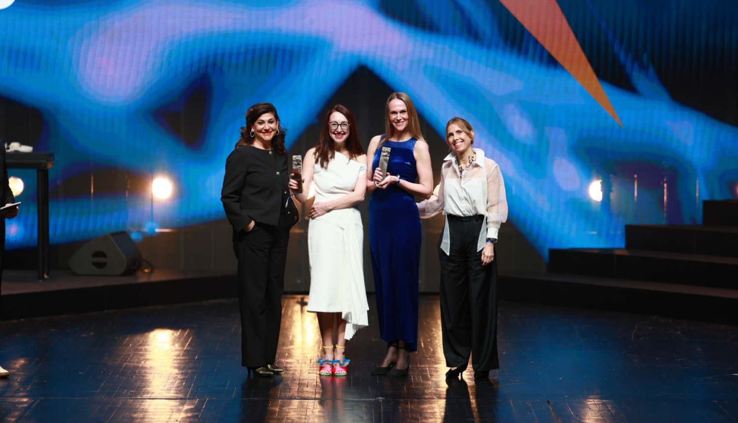 Producente Inese Lukaševska ar iegūtajām balvām uz skatuves Kanu festivāla "Heavent Awards"