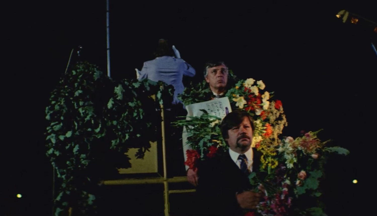 XXI Vispārējos latviešu dziesmu un XI deju svētkos dziesmas "Manai dzimtenei" atskaņojuma laikā 1985. gadā. Attēlā no augšas uz leju: Imants Kokars, Raimonds Pauls, Jānis Peters.