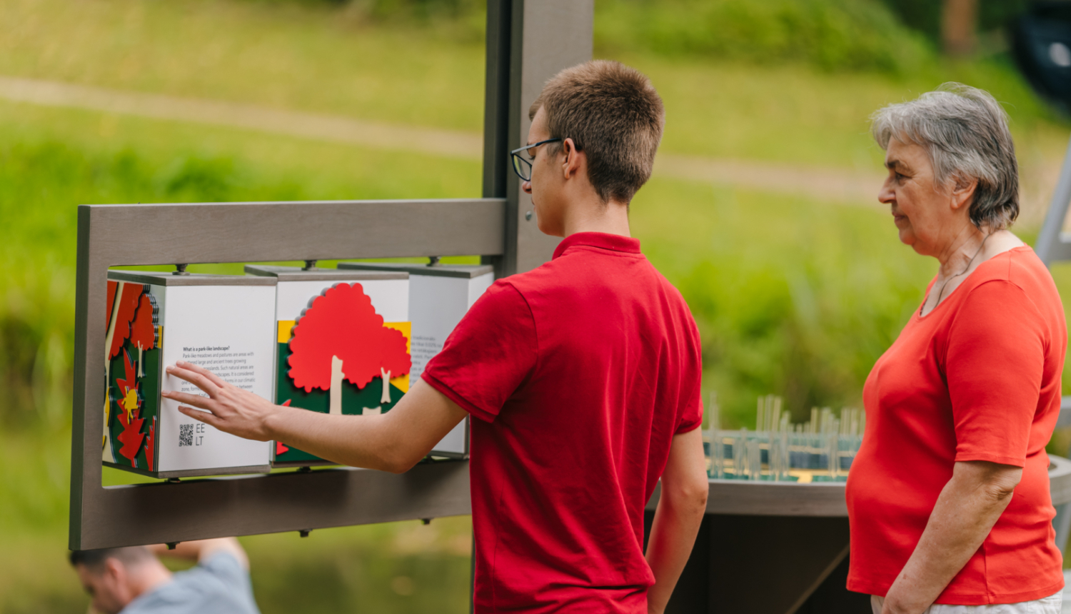 Cilvēki pie interaktīvas brīvdabas ekspozīcijas Turaidas muzejrzervātā