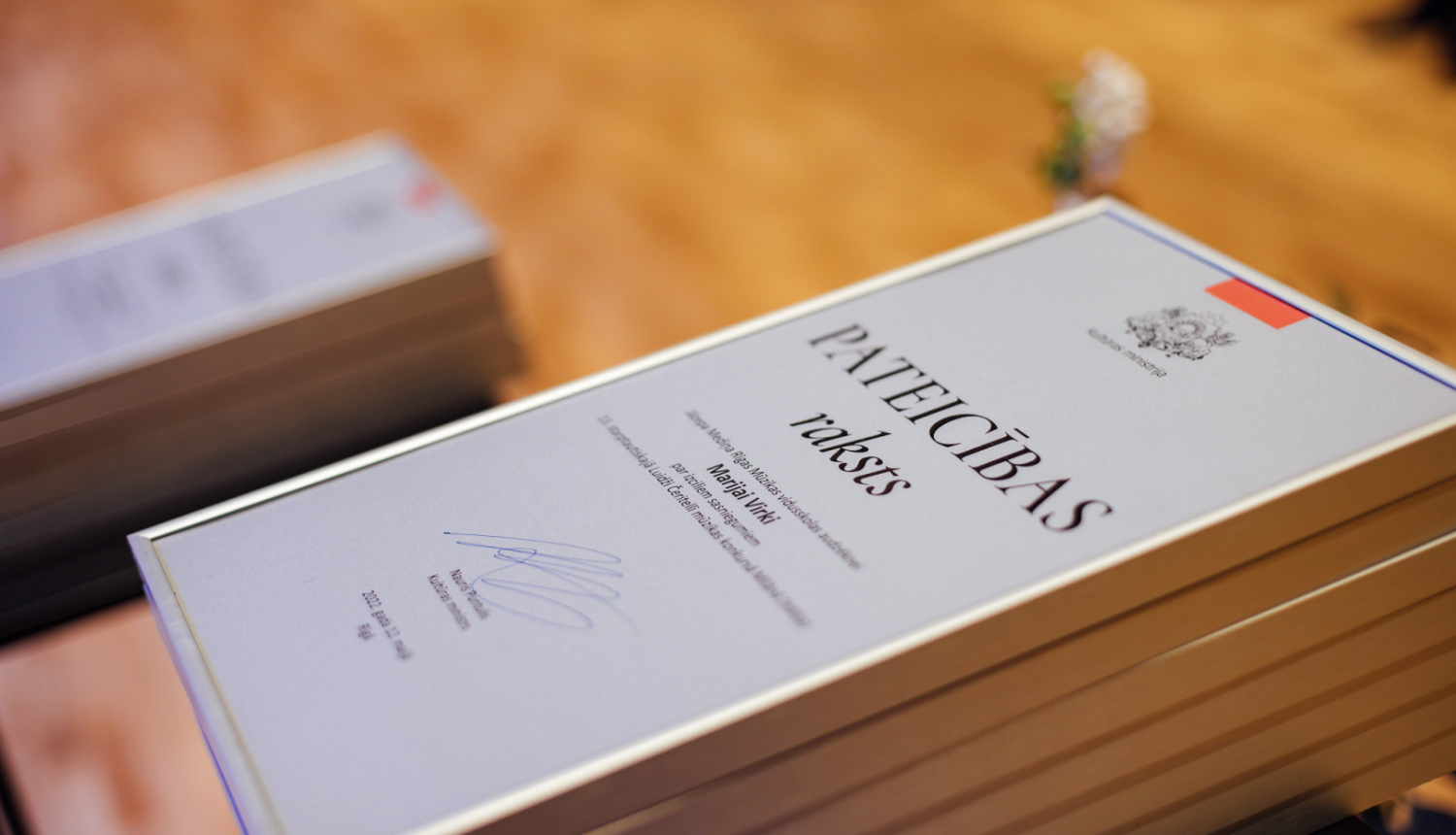 KM pateicības raksti uz galda